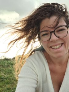 Vrouw met glimlach op haar gezicht en haar in de wind